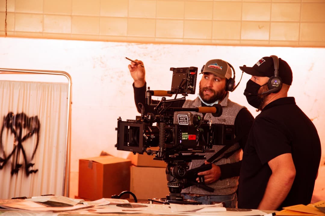 Behind the scenes photo 66 from Clone Cops production showing gaffer barrett dennison and cinematographer corey allen discuss lighting a shot for clone cops